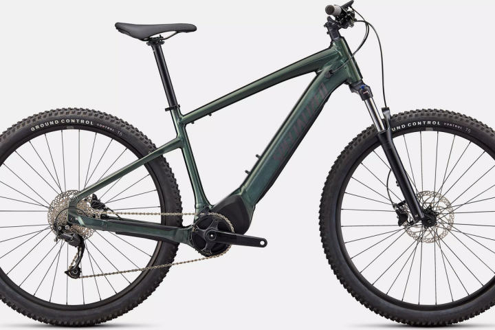 Green mountain bike with thick tires and front suspension.