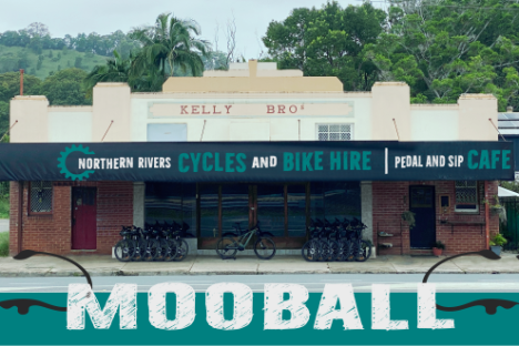 Old shopfront labeled 'Northern Rivers Cycles and Bike Hire, Café' with parked bicycles.