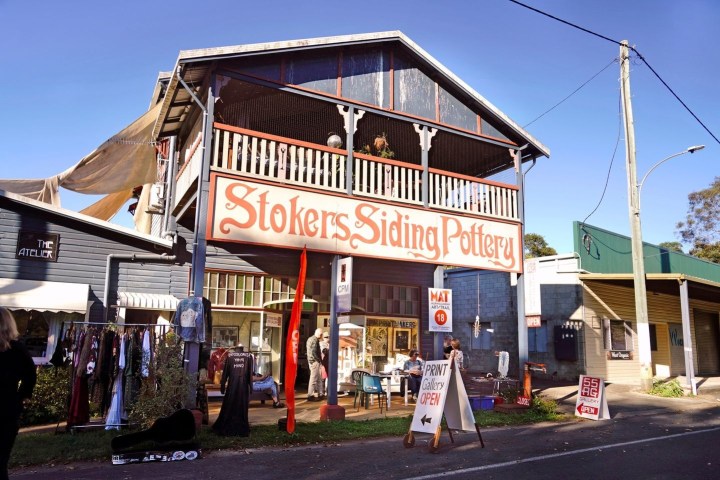 Street scene with Stokers Siding Pottery shop displaying art and clothes.