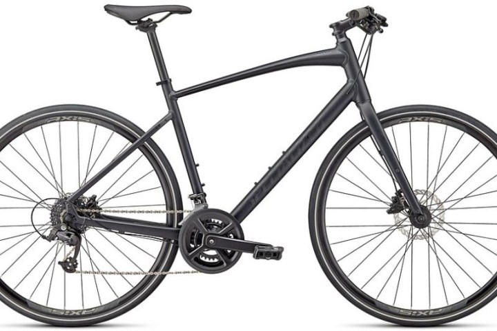 Black road bike with disc brakes and thin tires on a white background.