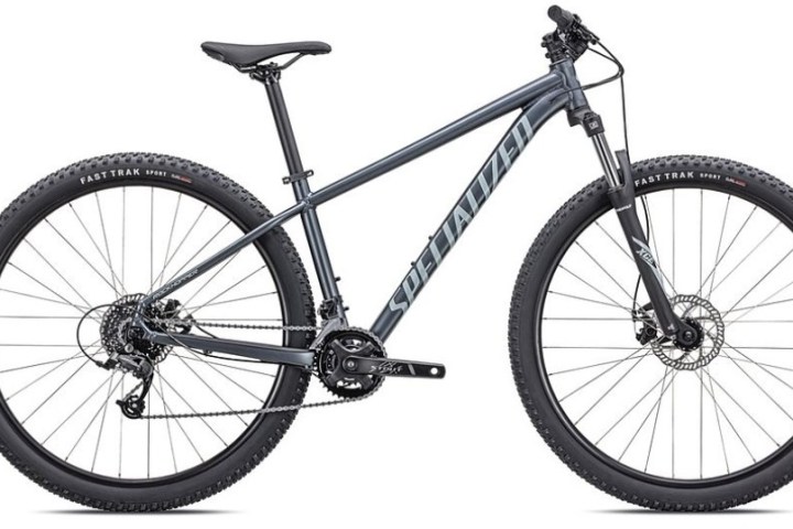 Gray mountain bike with front suspension and knobby tires on a white background.