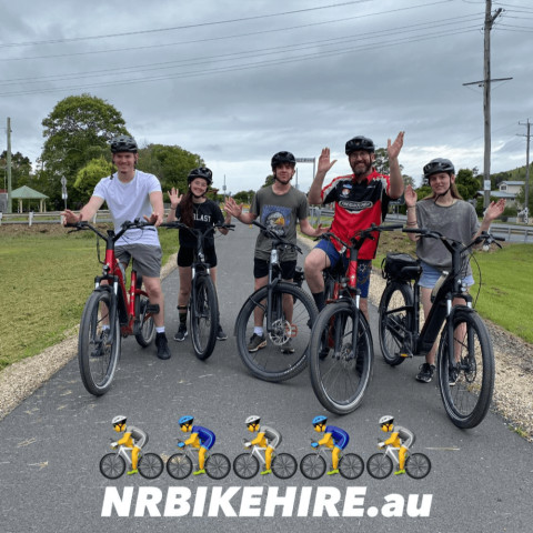 Five people on bikes waving on a path with NRBIKEHIRE.au banner below.