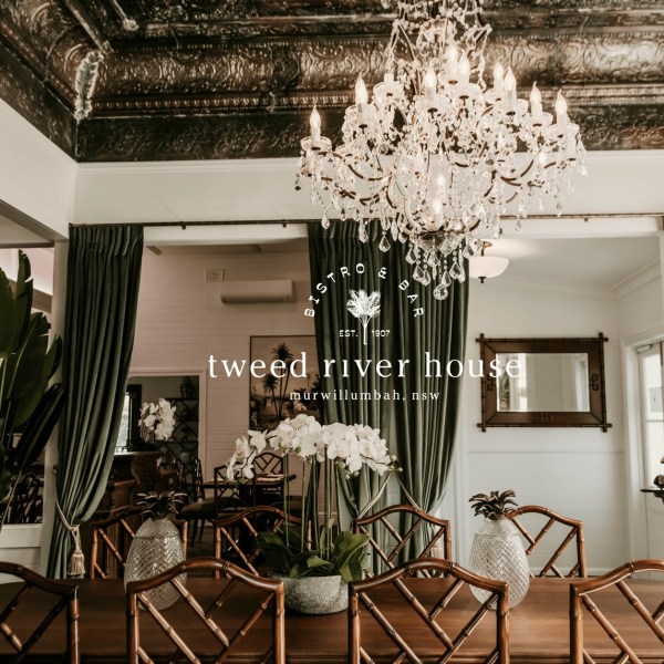 Elegant dining area with chandelier and green curtains at Tweed River House Bistro & Bar.