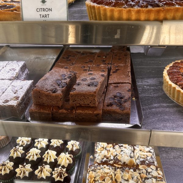 Pastry display with citron tart, chocolate brownies, mini red velvet cupcakes, and almond-topped bars.
